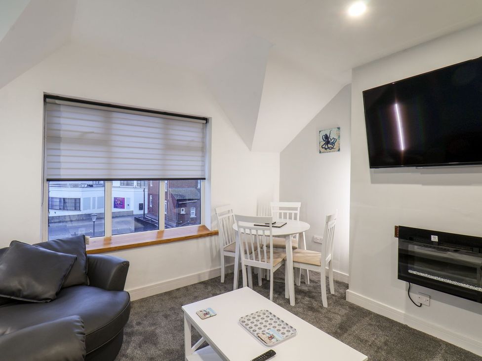 A living room with a table and chairs and a sofa at Frankie’s Seaview 5 in Bridlington