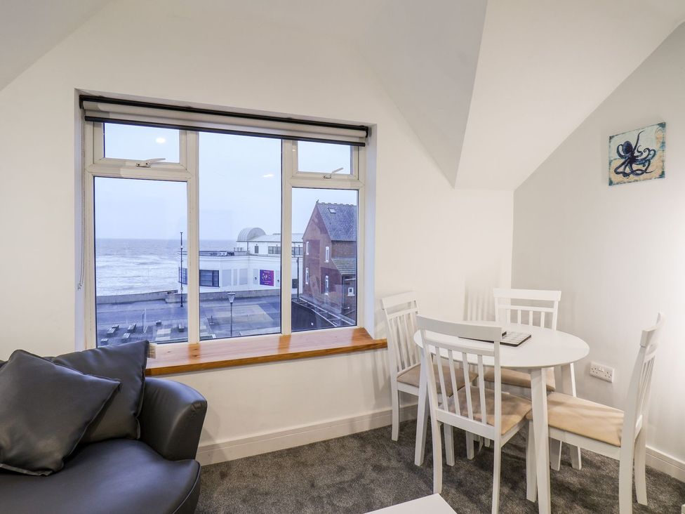 A living room with a window and dining table at Frankie’s Seaview 5 in Bridlington