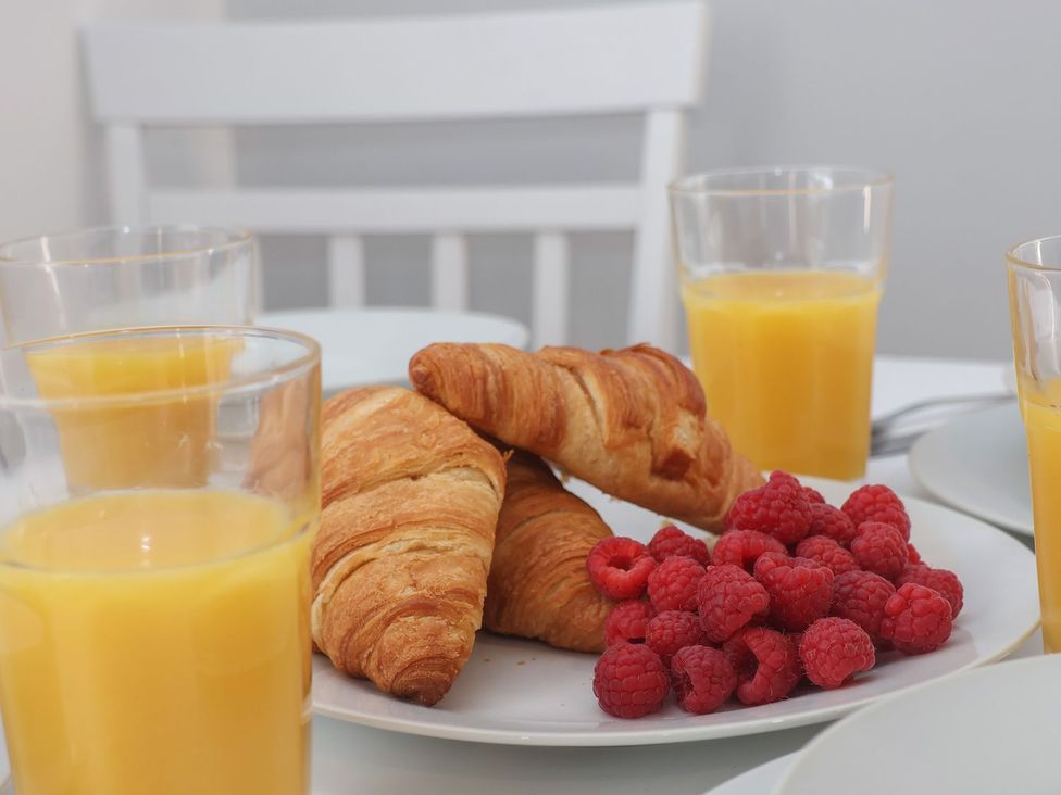 A kitchen table with croissants and raspberries at Frankie’s Seaview 5 in Bridlington