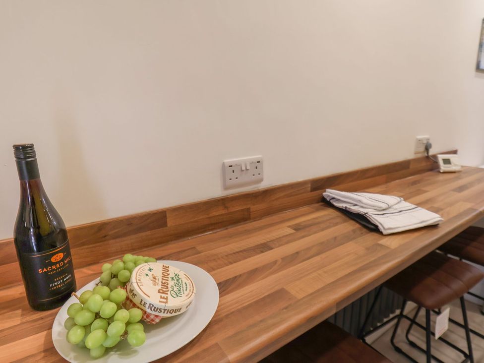 A kitchen counter with a wine bottle grapes and cheese at Frankie’s Seaview 5 in Bridlington