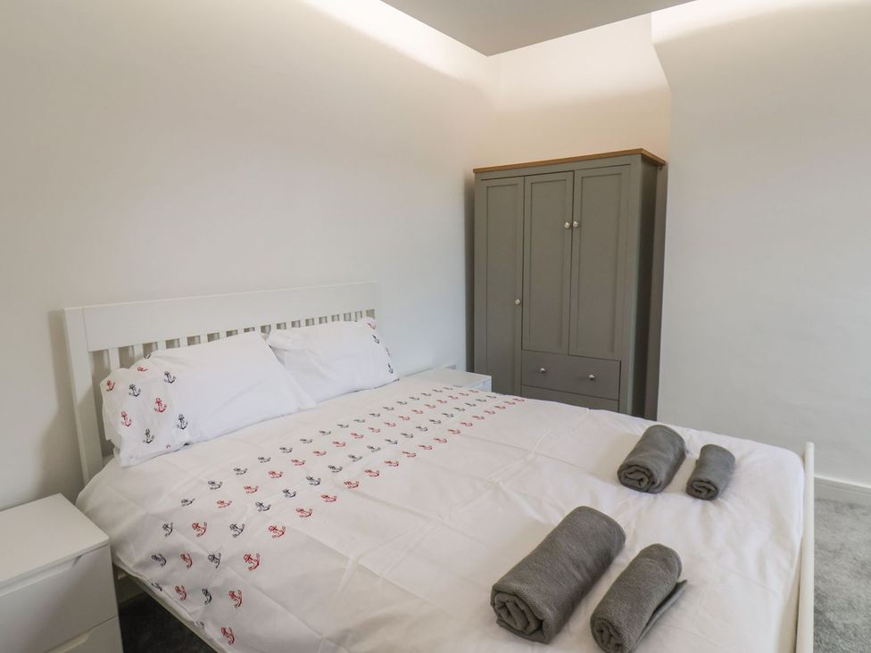 A bedroom with a bed and a wardrobe at Frankie’s Seaview 5 in Bridlington