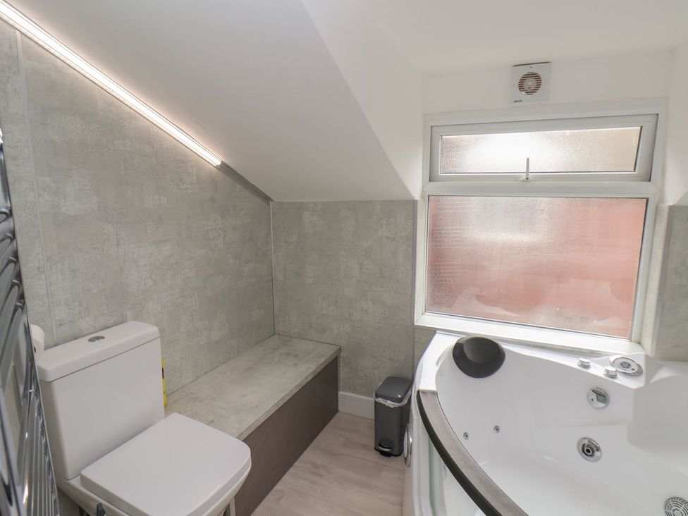 A bathroom with a toilet, bathtub and a window at Frankie’s Seaview 5 in Bridlington