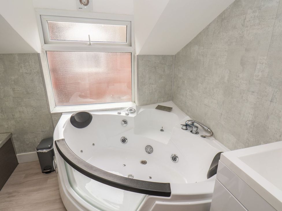 A bathroom with a bathtub and sink at Frankie’s Seaview 5 in Bridlington