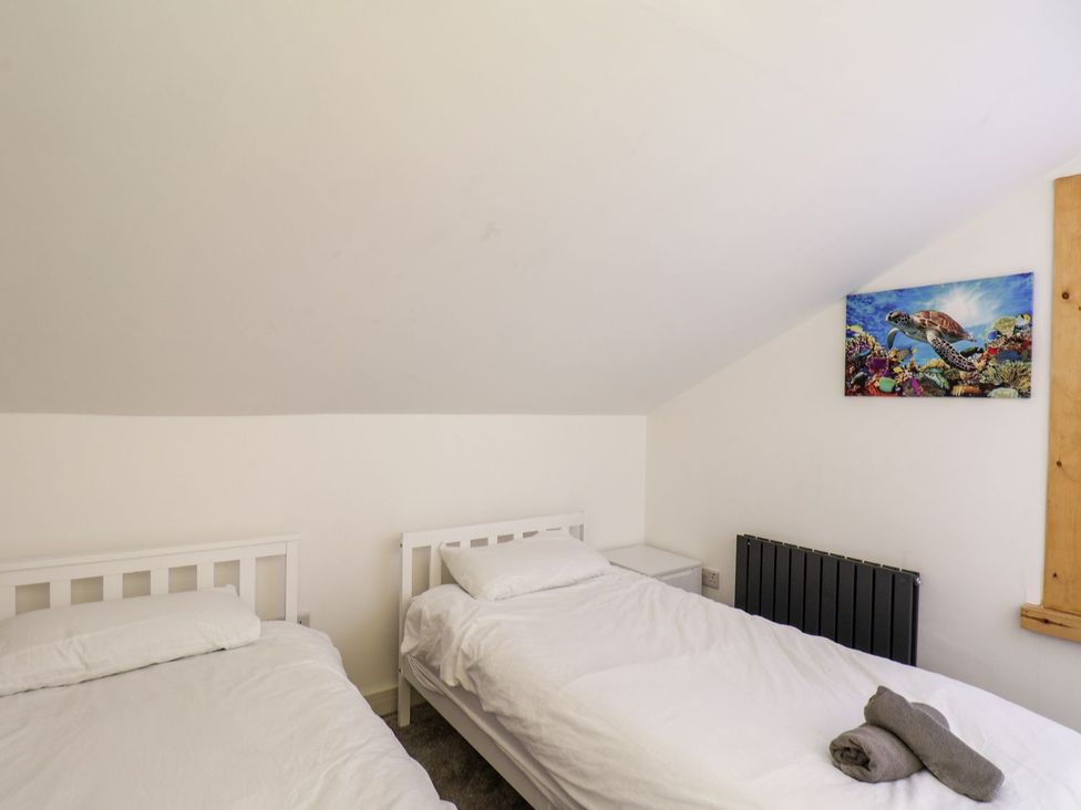 A bedroom with two beds and wall art at Frankie’s Seaview 5 in Bridlington