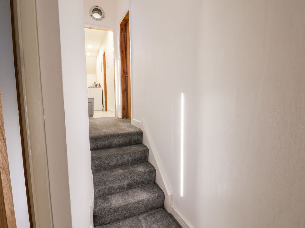 A staircase with a light fixture and doorway at Frankie’s Seaview 5 in Bridlington