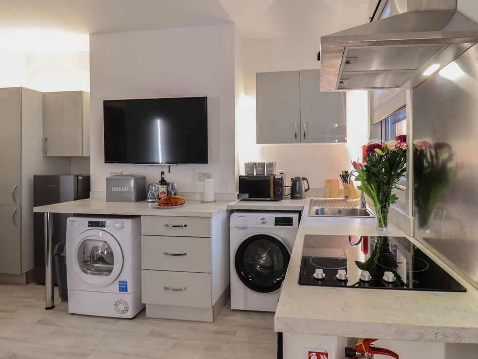 A kitchen with a washing machine and refrigerator at Frankie’s Seaview 3 in Bridlington