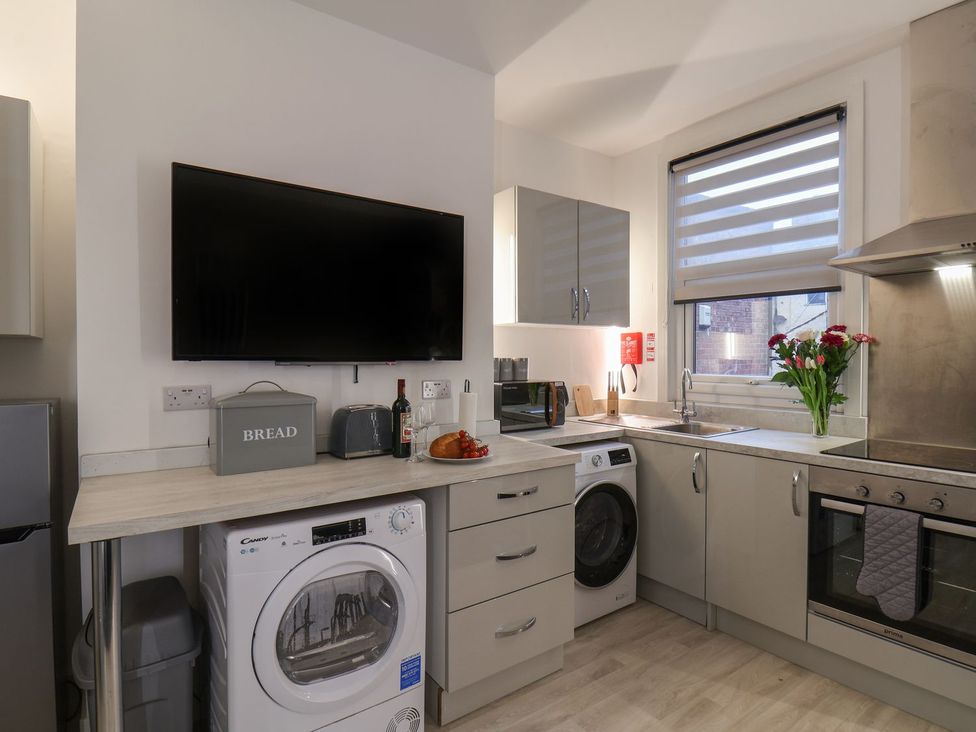 A kitchen with appliances and a drying machine at Frankie’s Seaview 3 in Bridlington