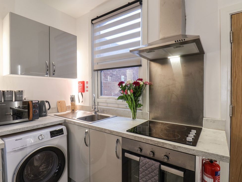 A kitchen with a stove and washing machine at Frankie’s Seaview 3 in Bridlington