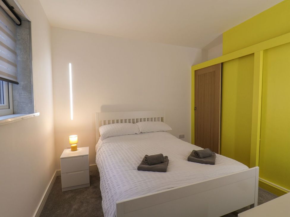 A bedroom with a bed and bedside table at Frankie’s Seaview 3 in Bridlington