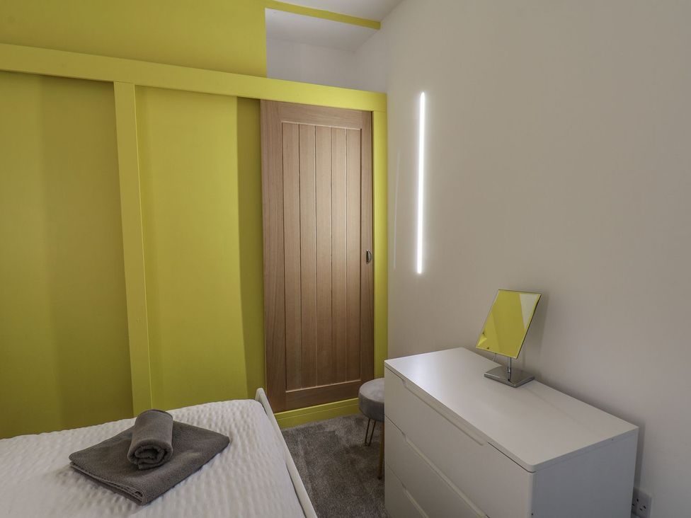 A bedroom with a bed and dresser at Frankie’s Seaview 3 in Bridlington