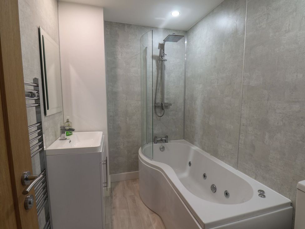 A bathroom with a bathtub and a sink at Frankie’s Seaview 3 in Bridlington