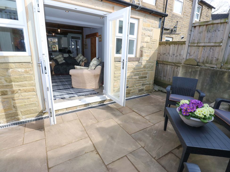 An outdoor space with patio furniture and flowers at Milburn Cottage in Keighley