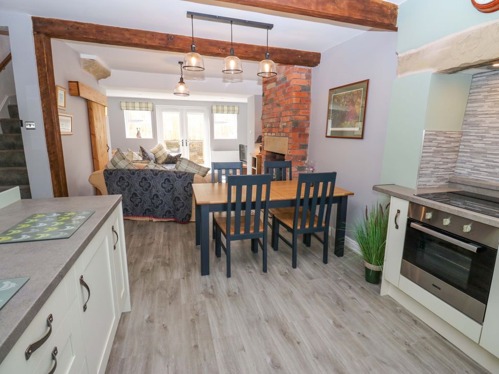 A dining area with a table and chairs at Milburn Cottage in Keighley