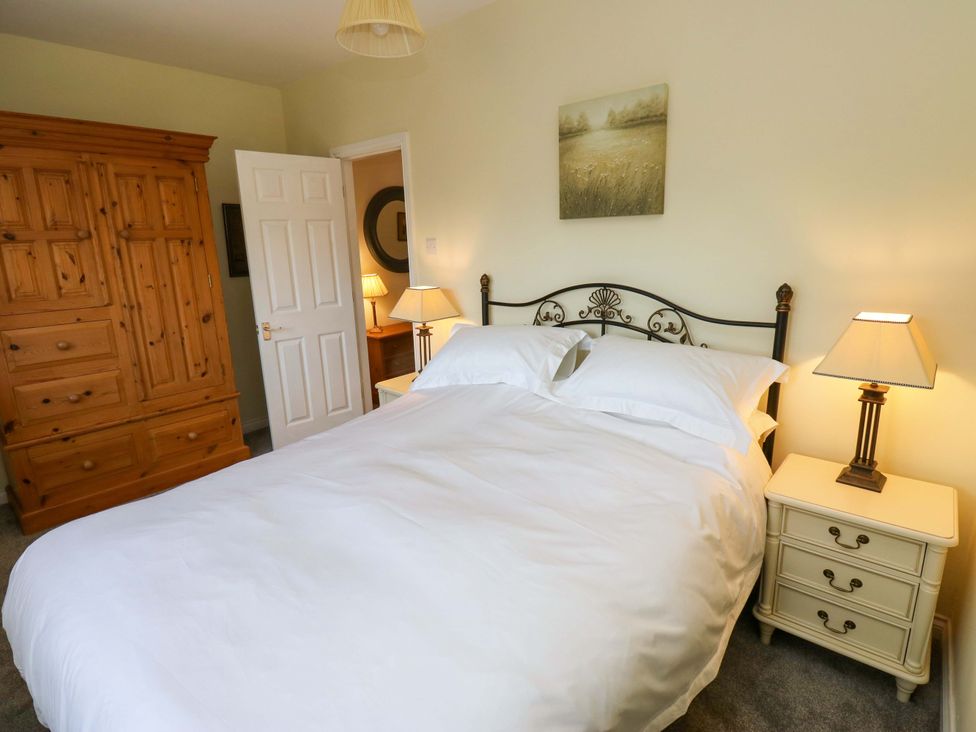 A bedroom with a bed and wardrobe at Milburn Cottage in Keighley