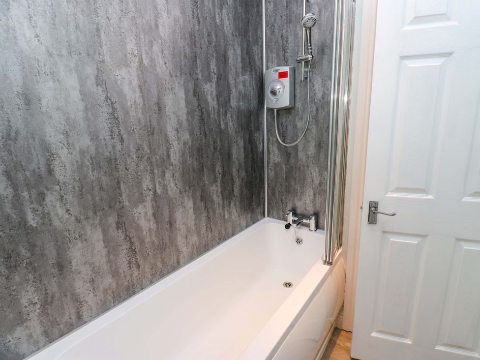 A bathroom with a bathtub and shower at Milburn Cottage in Keighley