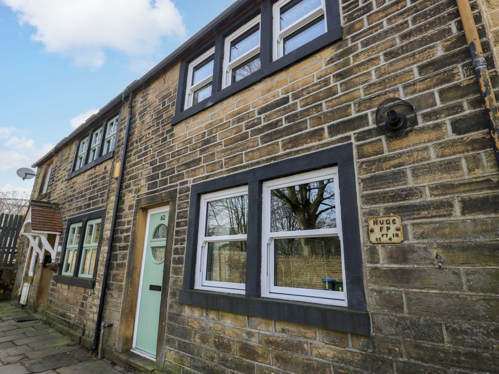 A house exterior with windows and a door at Milburn Cottage in Keighley