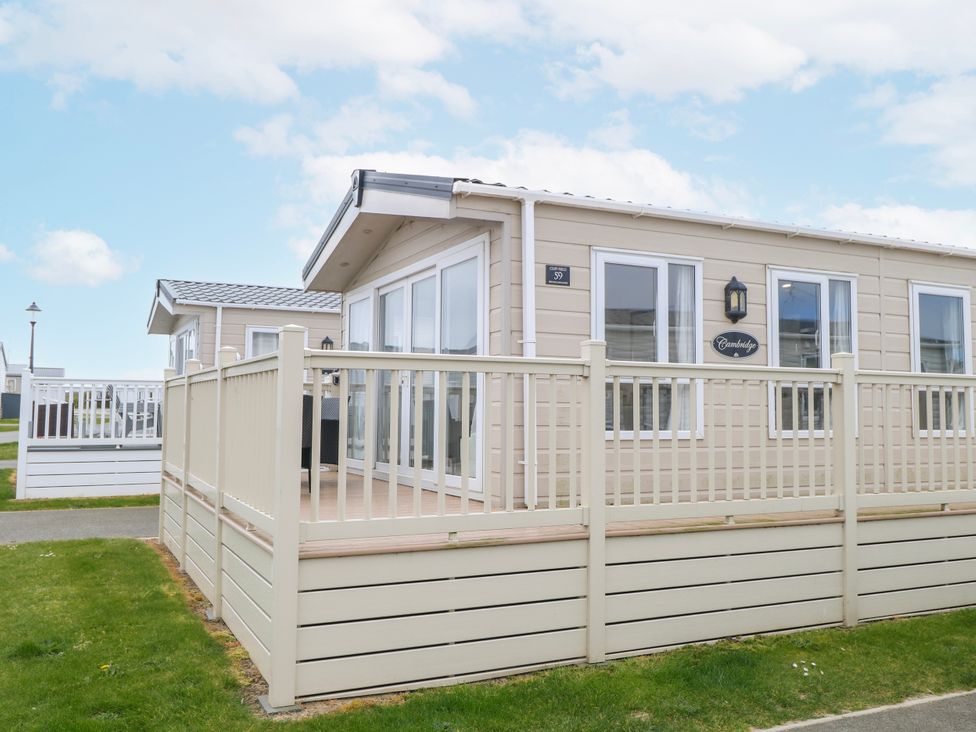 A cabin with a deck and windows at 59 Cliff Field in Lowestoft