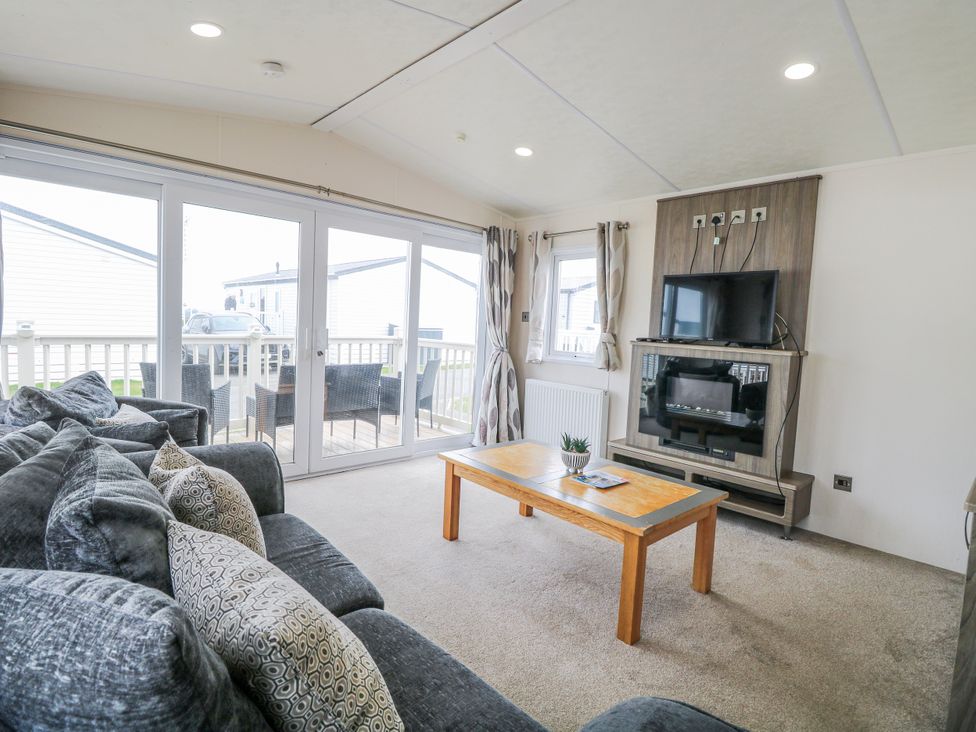 A living room with a sofa and coffee table at 59 Cliff Field in Lowestoft