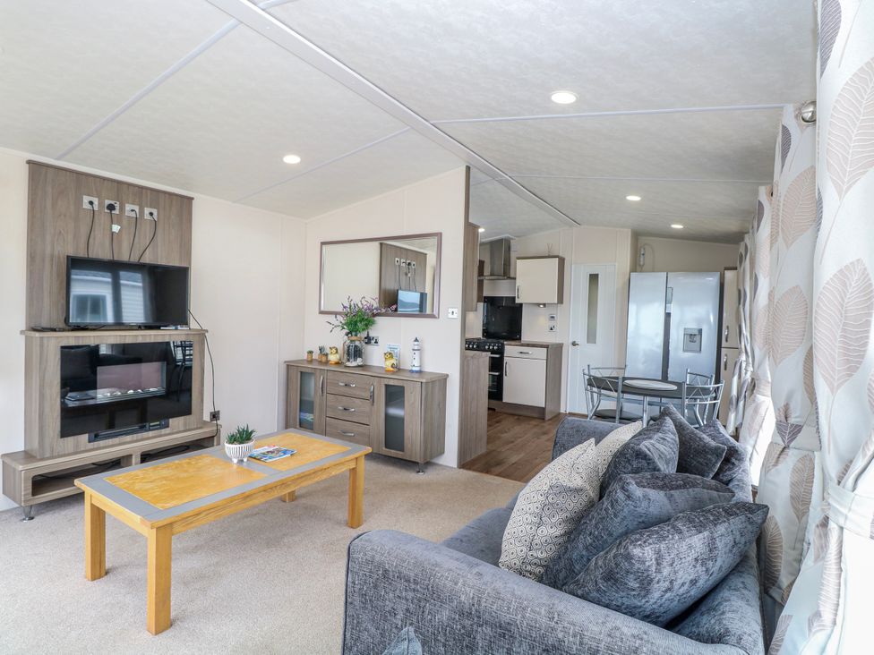 A living room with sofa and TV at 59 Cliff Field in Lowestoft