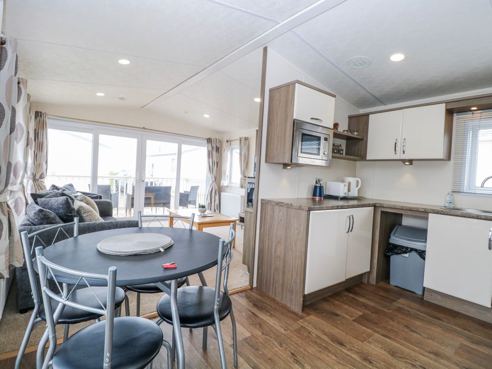 A living room with a table and chairs at 59 Cliff Field in Lowestoft