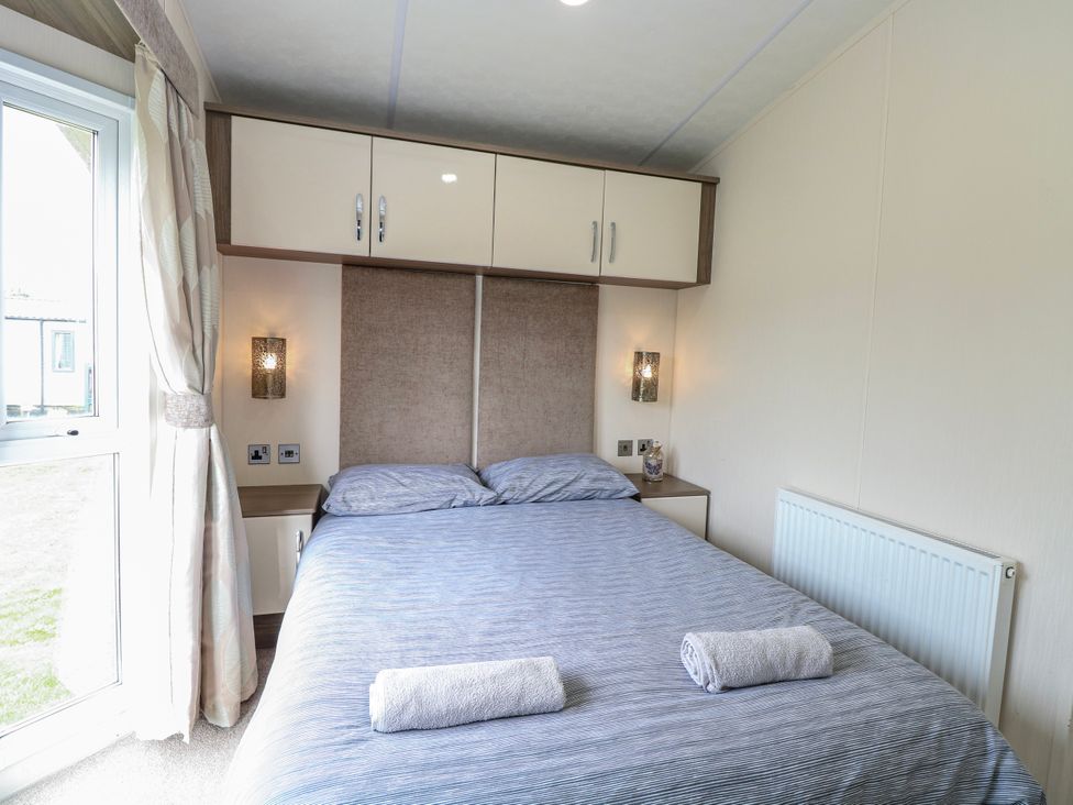 A bedroom with a double bed and window at 59 Cliff Field in Lowestoft