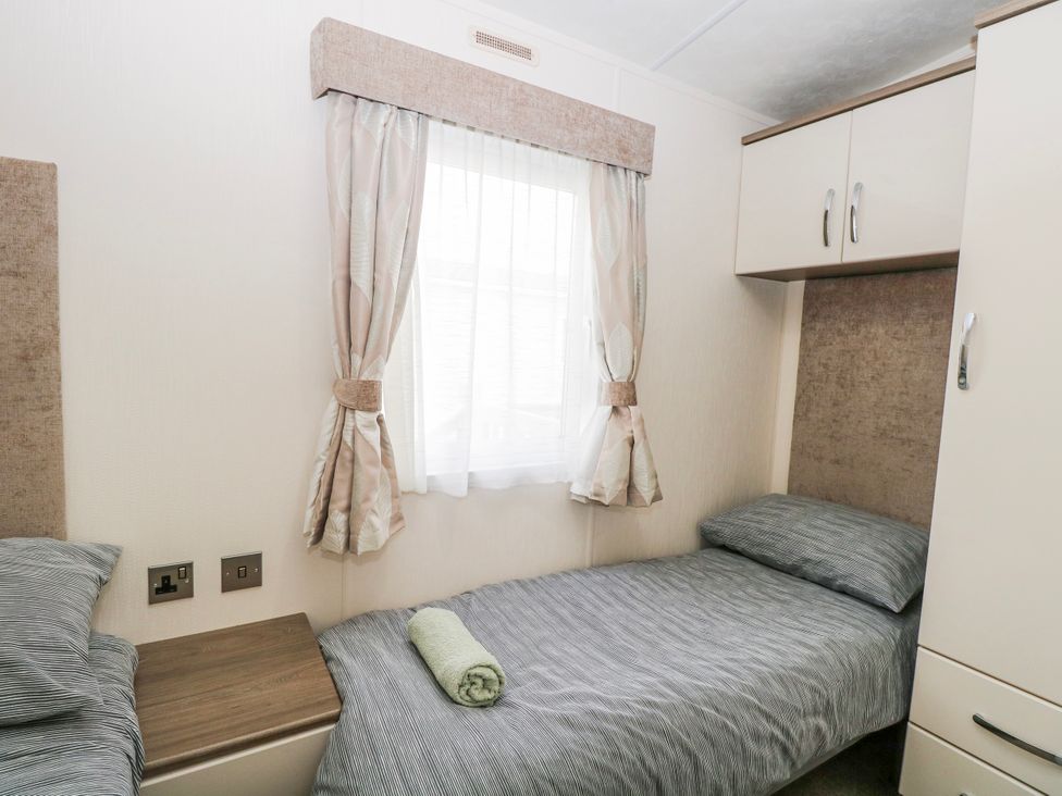 A bedroom with a bed and window at 59 Cliff Field in Lowestoft