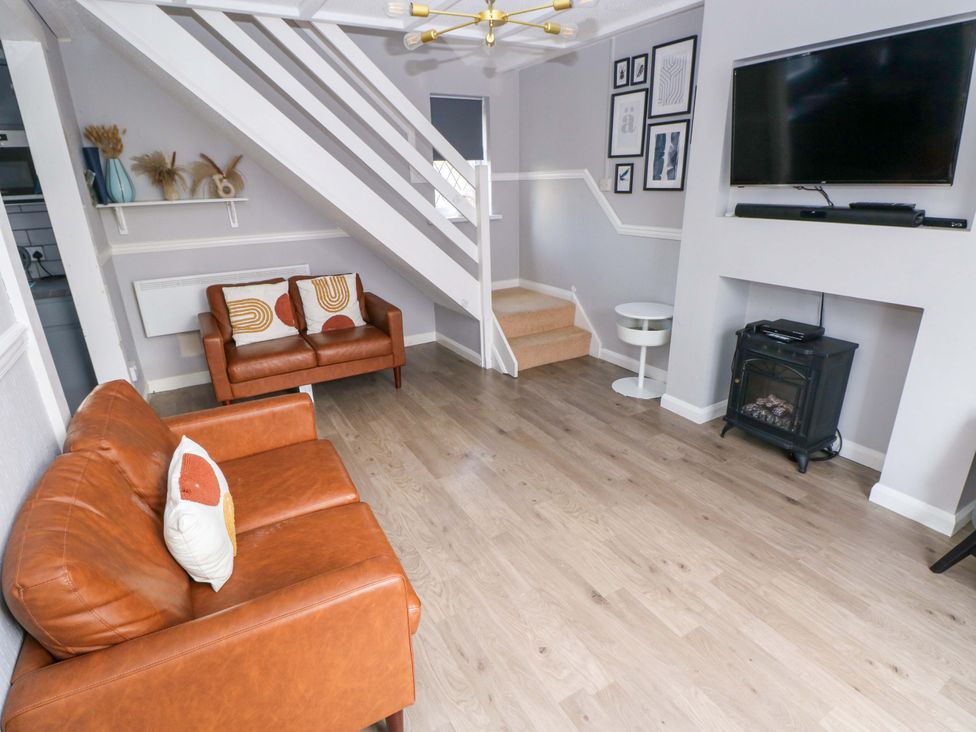 A living room with a sofa and television at The Wool Pack in Tenby