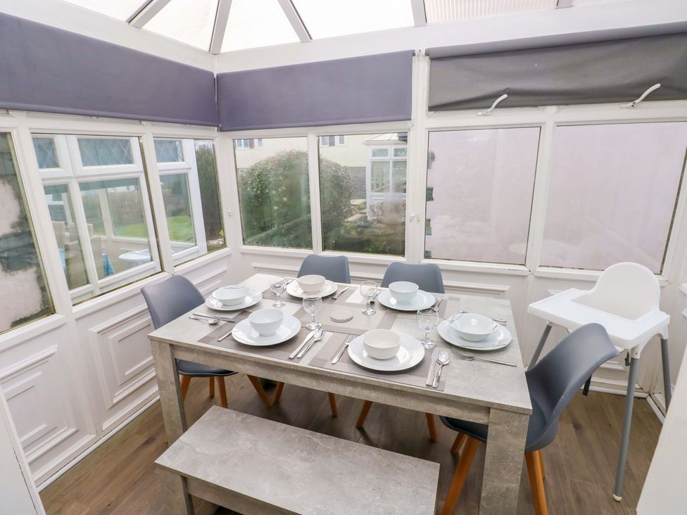 A dining table with tableware and chairs at The Wool Pack in Tenby