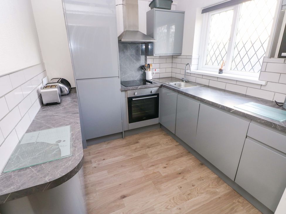 A kitchen with a sink and oven at The Wool Pack in Tenby
