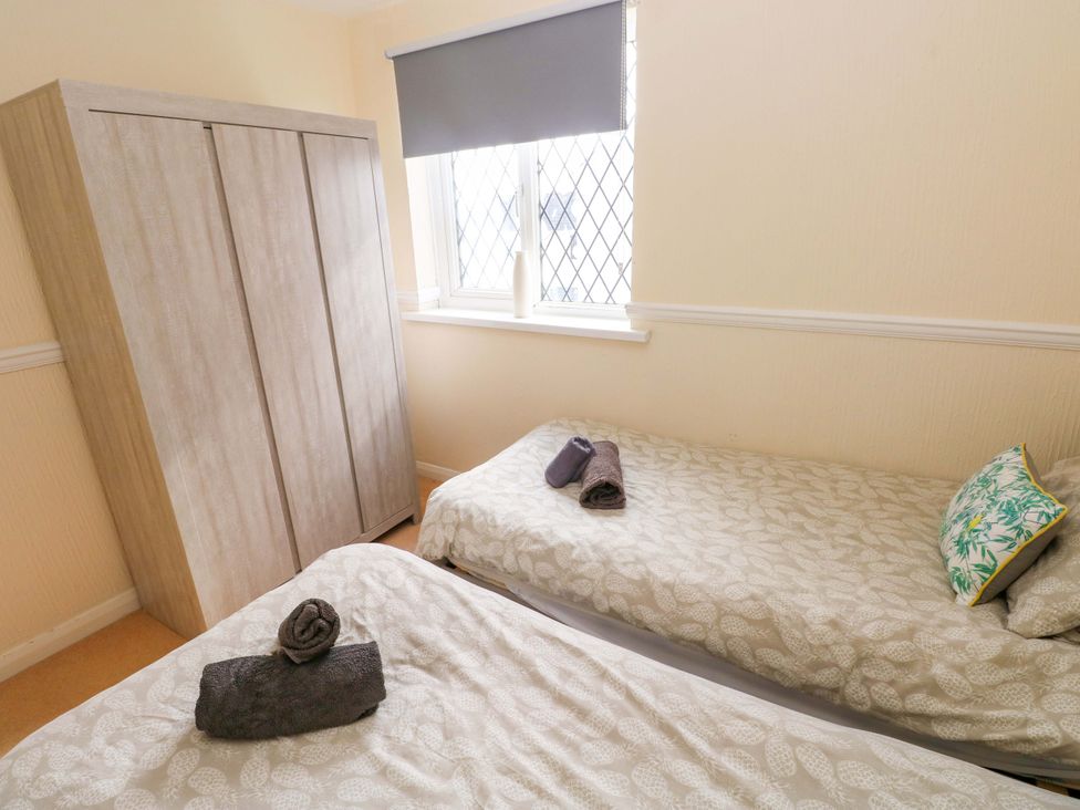 A bedroom with two beds and a wardrobe at The Wool Pack in Tenby