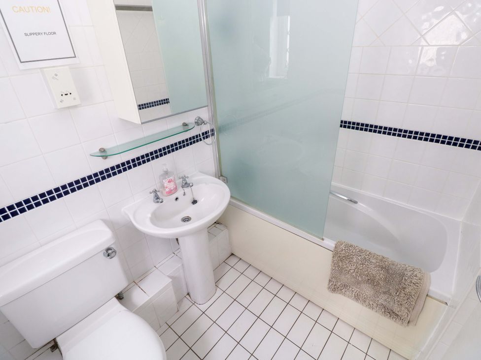 A bathroom with a toilet, sink, and bathtub at The Wool Pack in Tenby