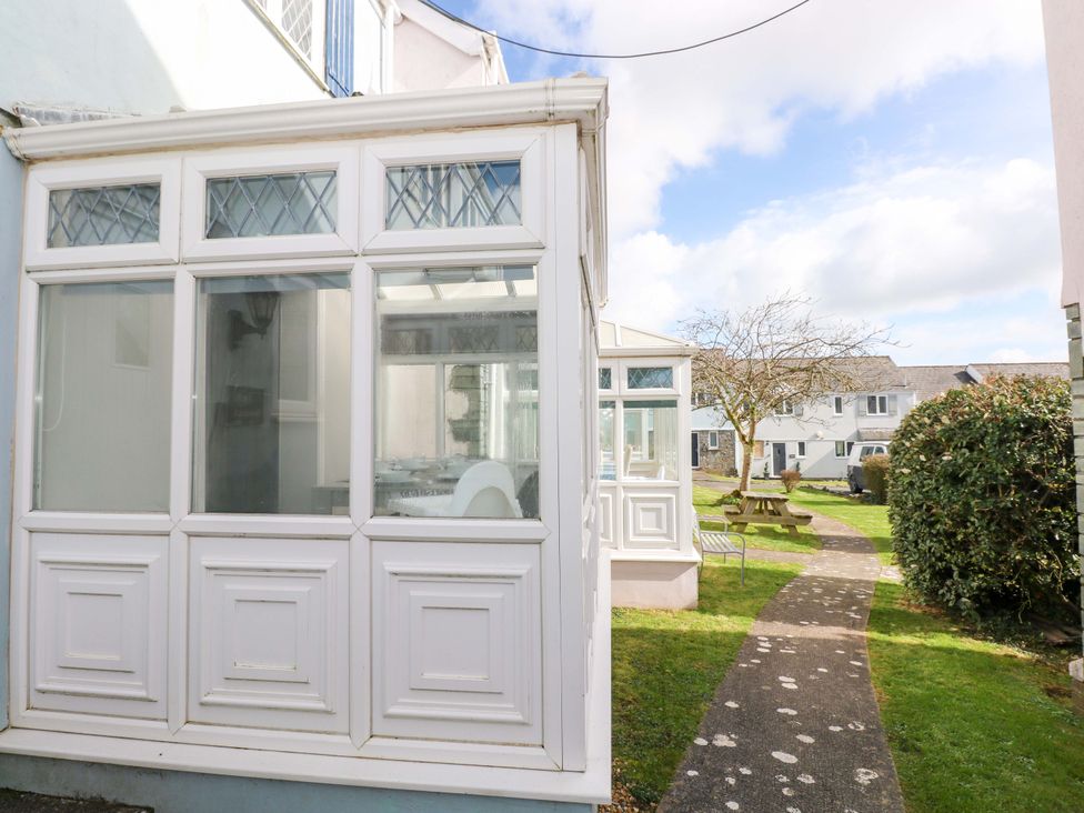 A conservatory and pathway in a garden at The Wool Pack in Tenby