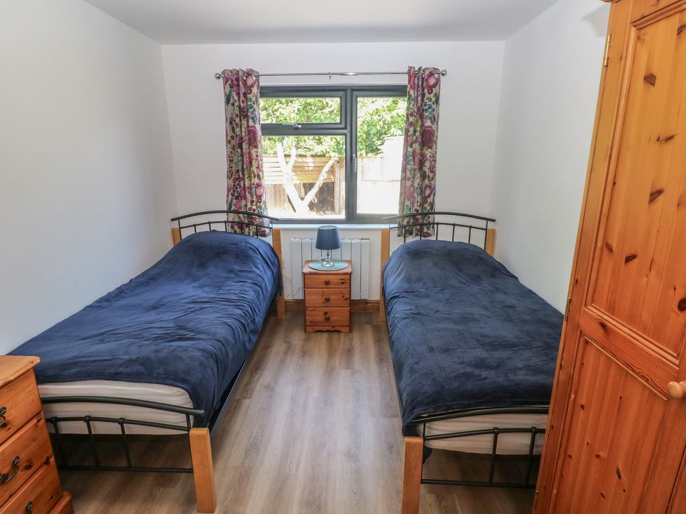 A bedroom with two single beds and a nightstand at Brookview Kingfisher Haverfordwest