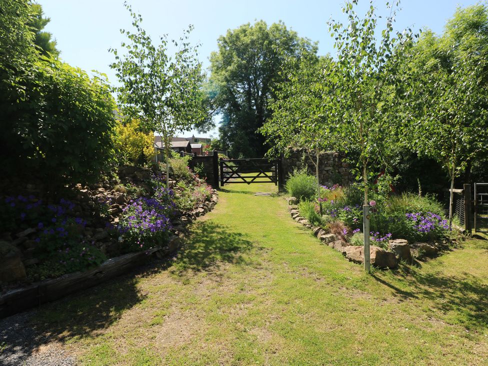 A garden with trees and flowers at Brookview Kingfisher in Haverfordwest