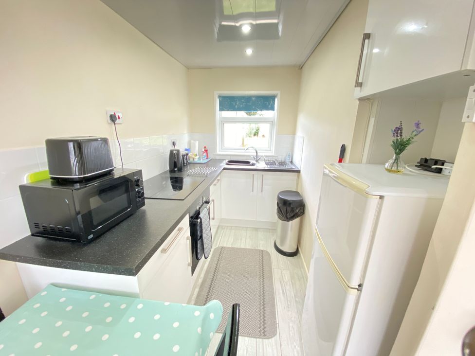 A kitchen with a sink and appliances at Chalet 62 in California, Norfolk