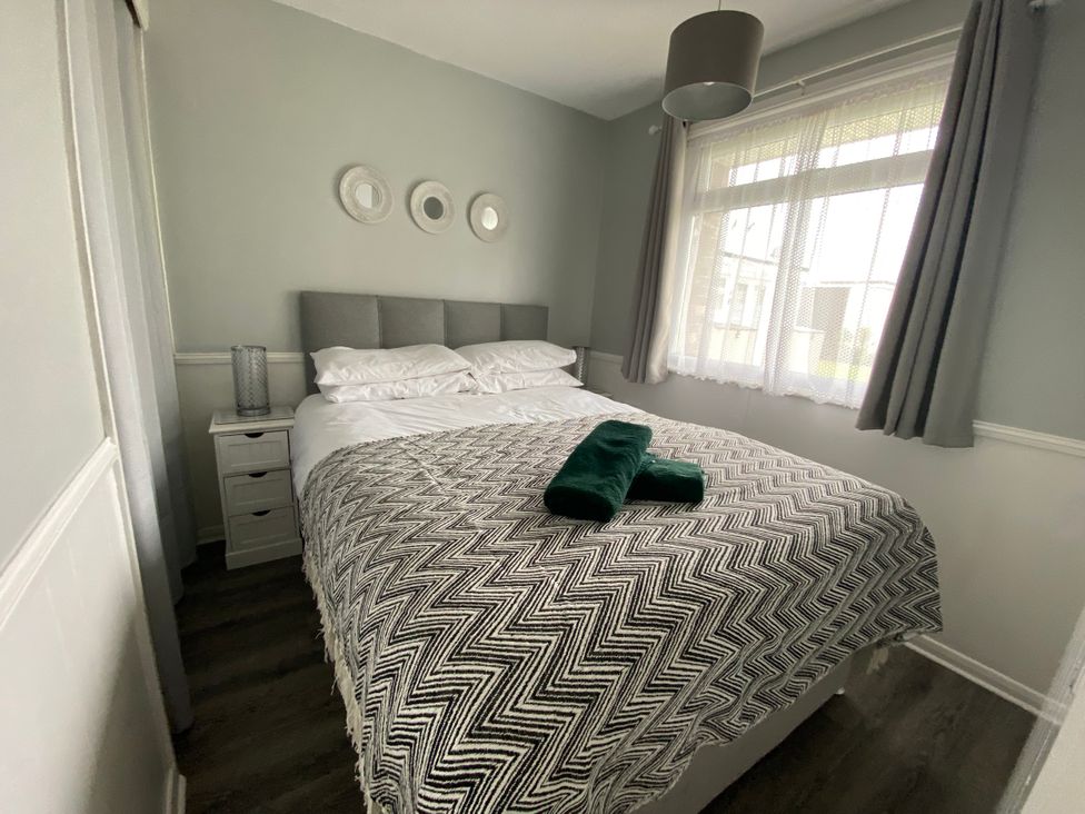 A bedroom with a bed and nightstand at Chalet 57 in California, Norfolk