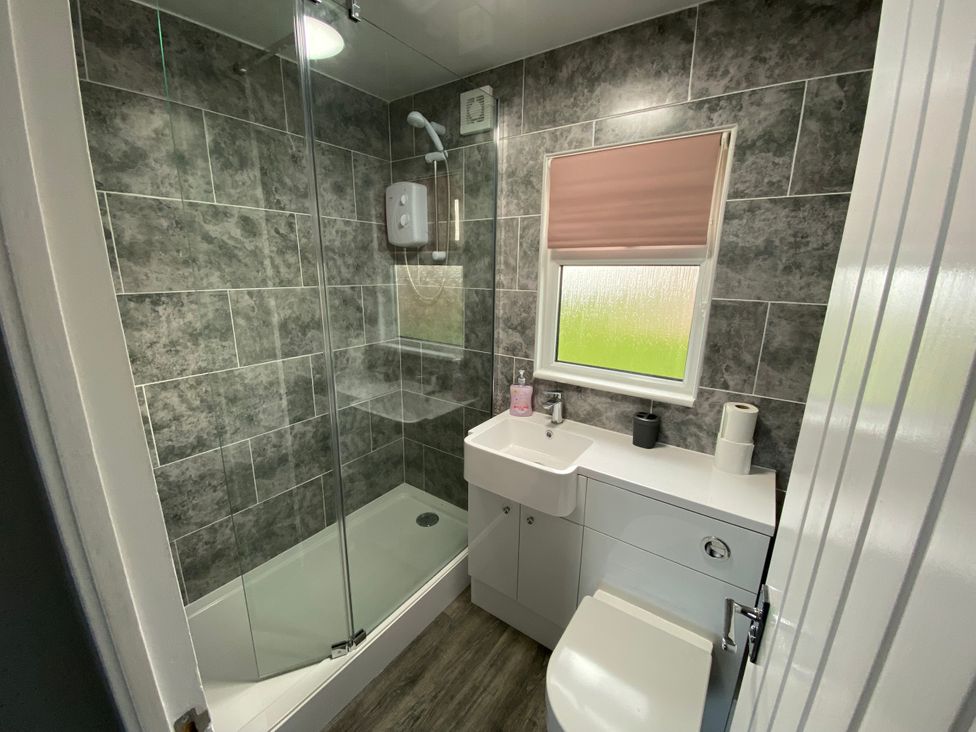 A bathroom with a shower, toilet, and sink at Chalet 57 California, Norfolk