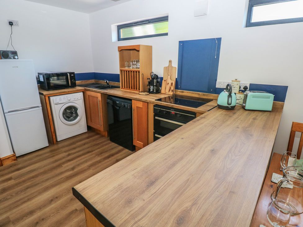 A kitchen with appliances including a microwave and washing machine at Brookview Goldfinch, Haverfordwest