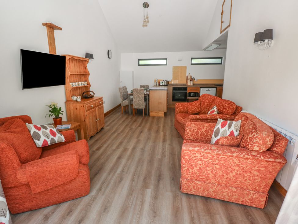 A living room with a television and dining area at Brookview Goldfinch in Haverfordwest