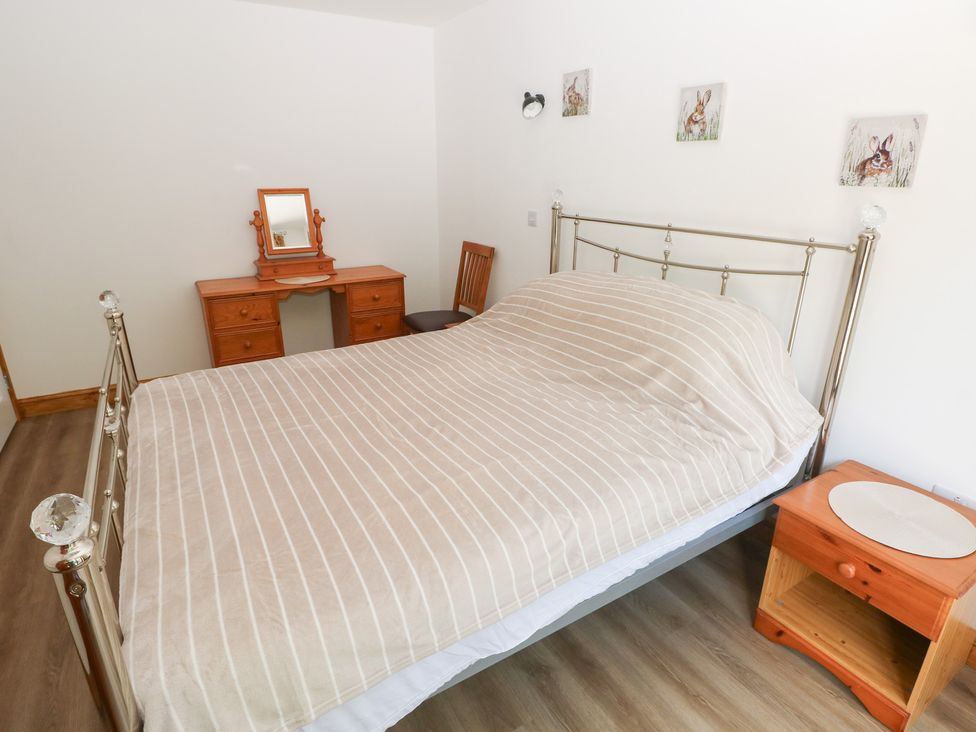 A bedroom with a bed and dressing table at Brookview Goldfinch in Haverfordwest