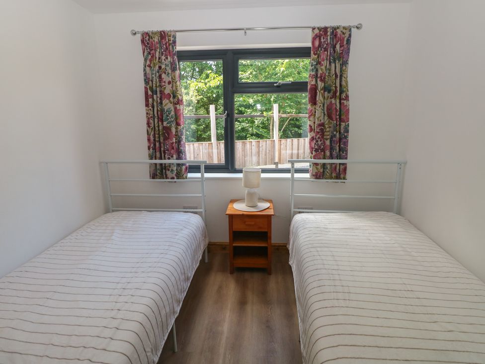 A bedroom with two single beds and a nightstand at Brookview Goldfinch in Haverfordwest