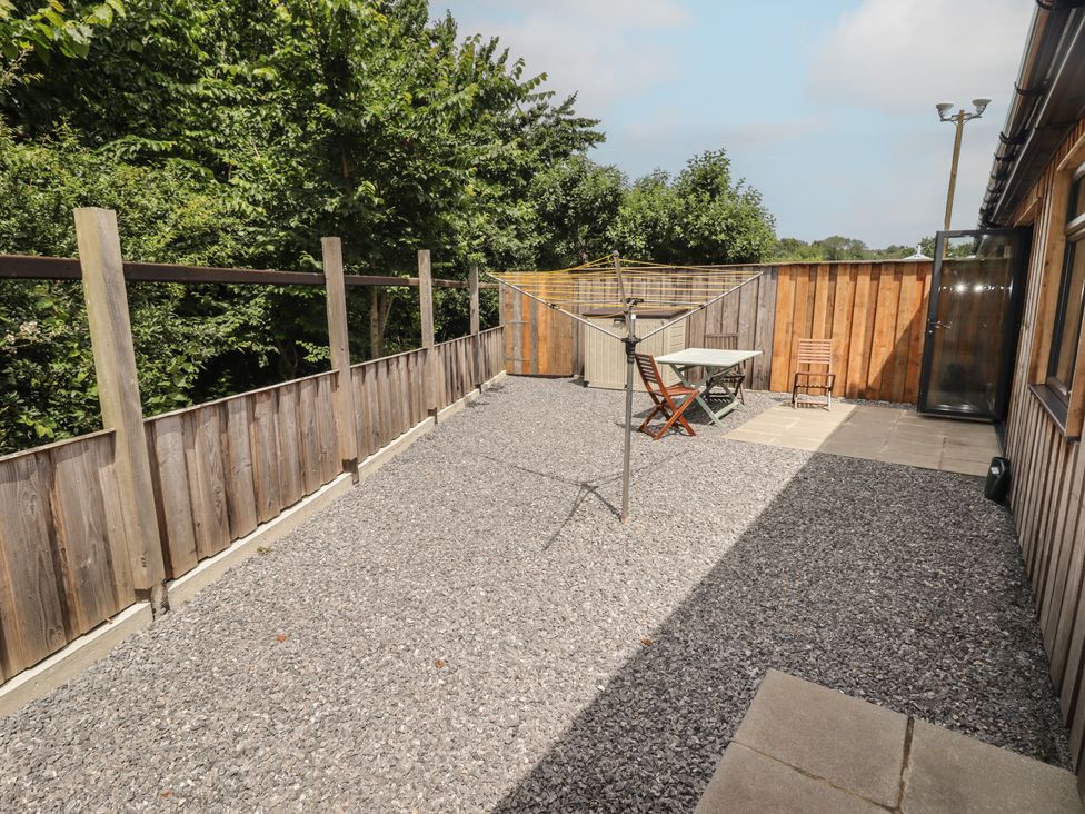 A garden with a table and chair at Brookview Goldfinch in Haverfordwest