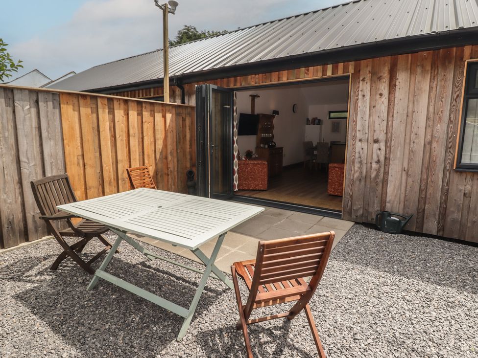 An outdoor seating area with a table and chairs at Brookview Goldfinch in Haverfordwest