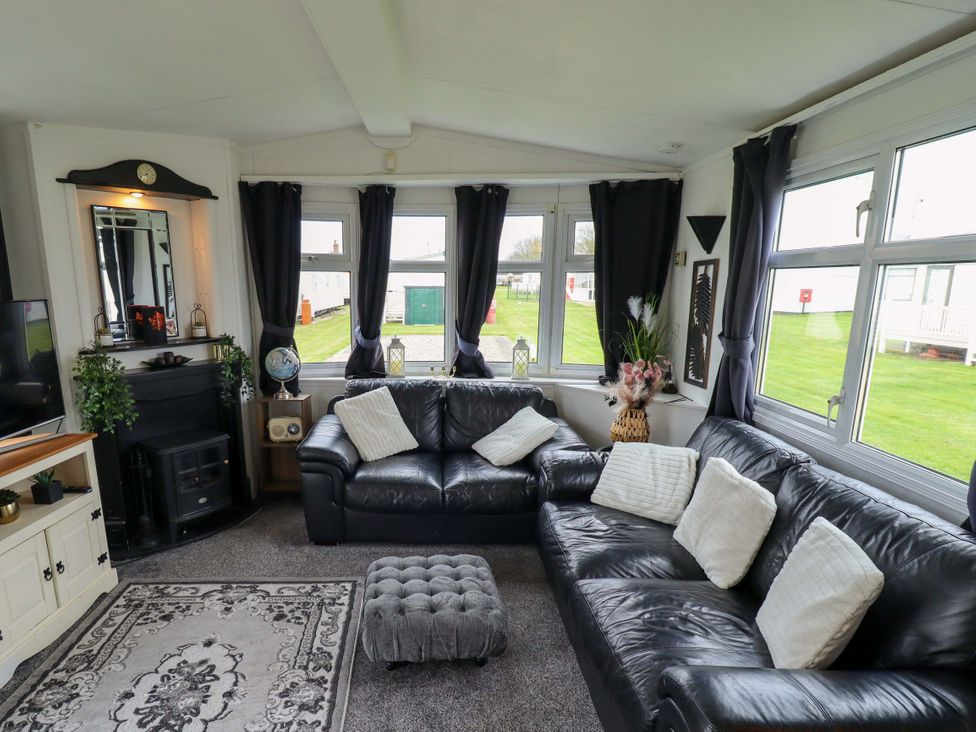 A living room with a sofa and television at Towervans Z11 in Mablethorpe
