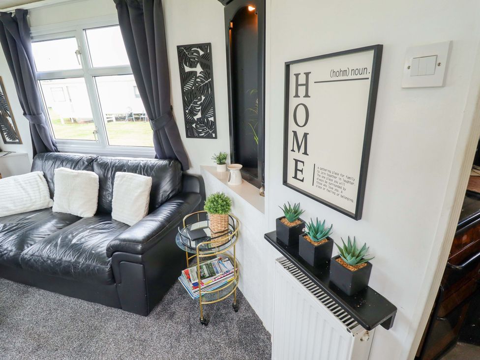 A living room with a sofa and wall decor at Towervans Z11 in Mablethorpe