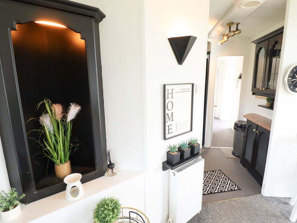 An entryway with plants and a decorative sign at Towervans Z11 in Mablethorpe