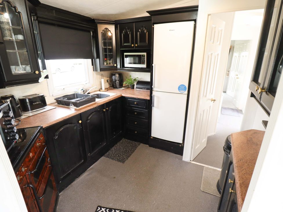 A kitchen with cabinets, refrigerator and sink at Towervans Z11 in Mablethorpe