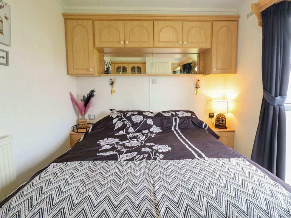 A bedroom with a bed and wall cabinets at Towervans Z11 in Mablethorpe