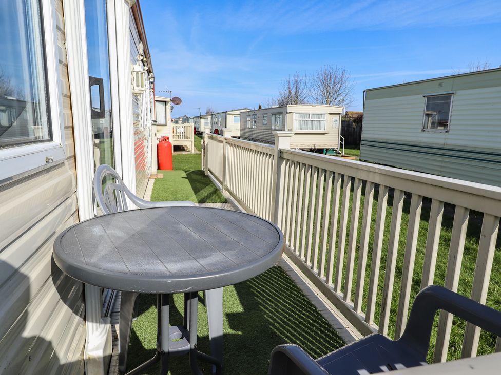 A balcony with a table and chair at Towervans Z11 Mablethorpe