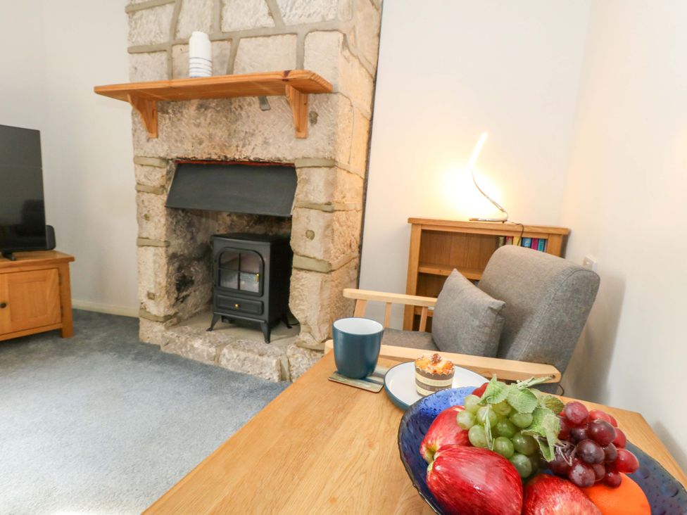 A living room with a fireplace and wooden furniture at NO 10 Fortuneswell